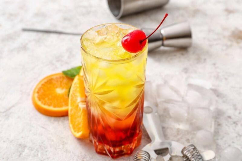 A land mine cocktail that has red at the bottom and yellow nearer the top, with plenty of ice