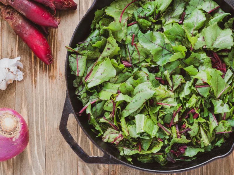 A large black dish of beet greens