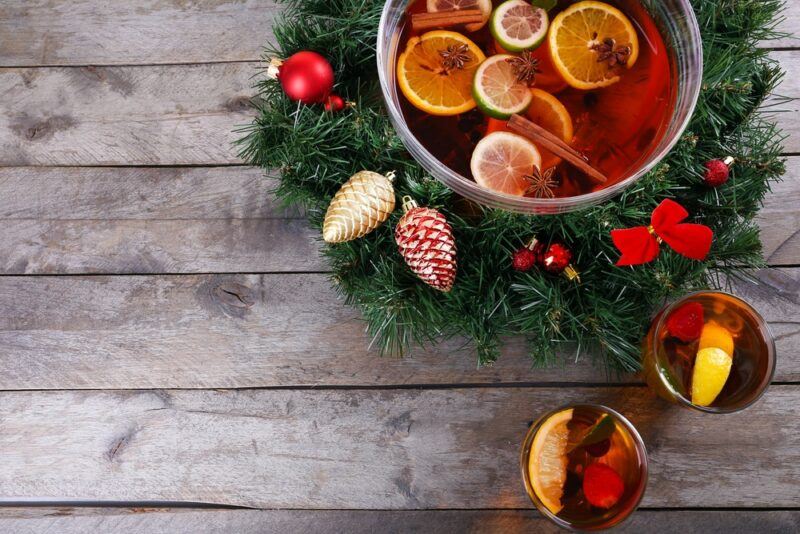 A large bowl of Christmas punch, surrounded by Christmas pines