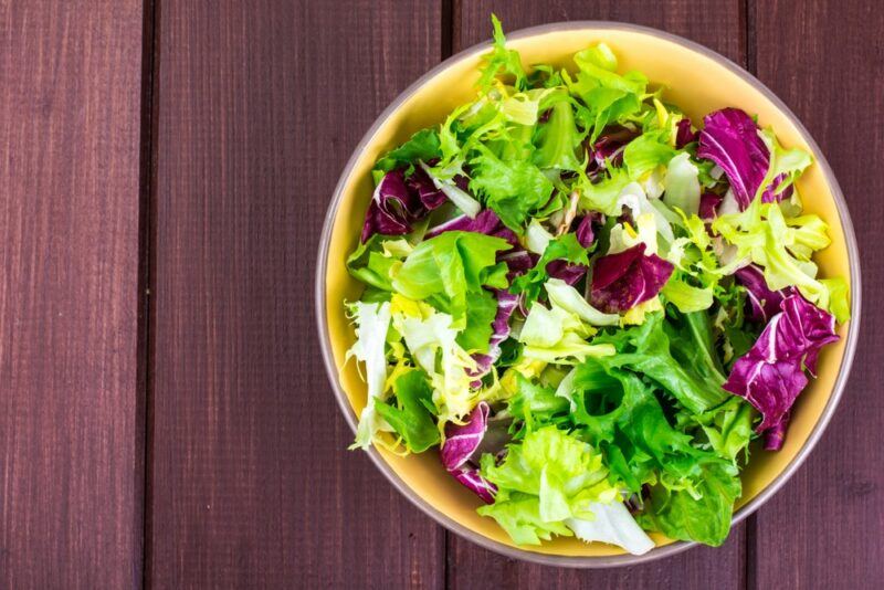 A large bowl filled with fresh lettuce of different colors