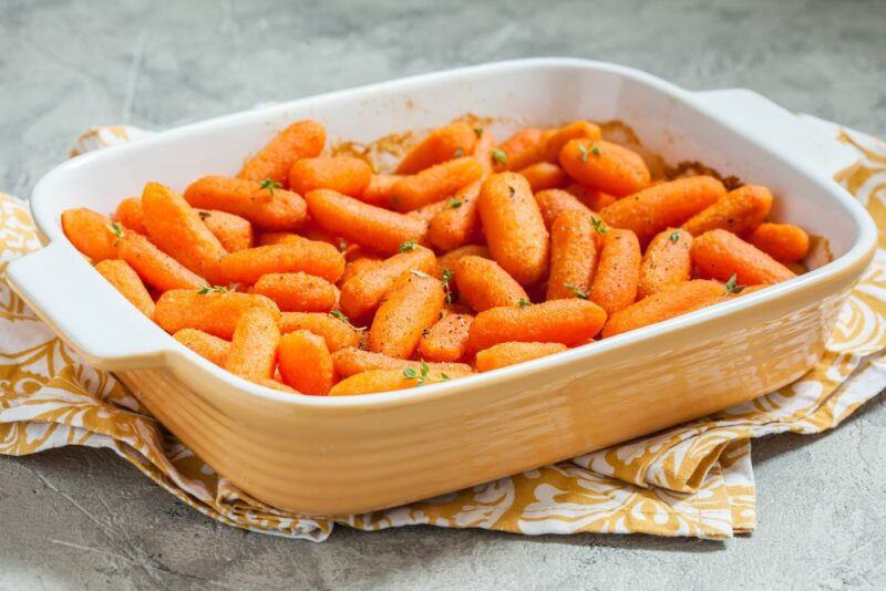 A large oblong oven dish filled with baby carrots