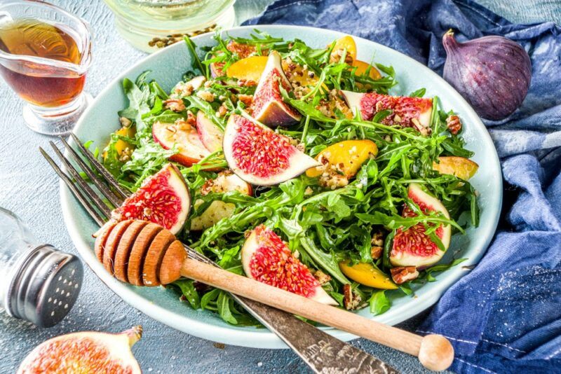 A light blue bowl with a fig and honey salad