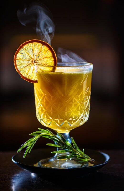 A large glass of hot buttered gin with a slice of lemon