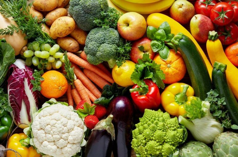 A selection of fresh veggies and fruit, including cauliflower and peppers