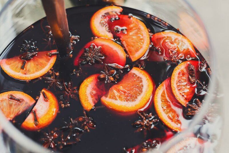 A large pot of mulled wine with plenty of oranges