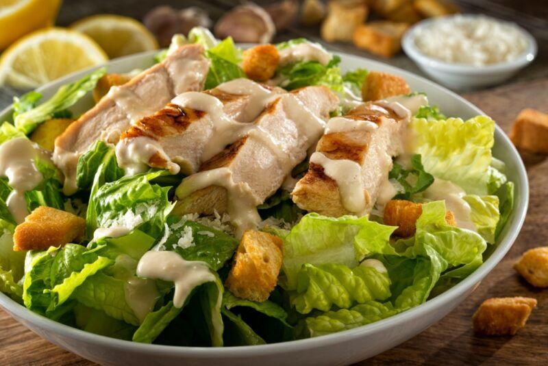 A large dish with a chicken Caesar salad