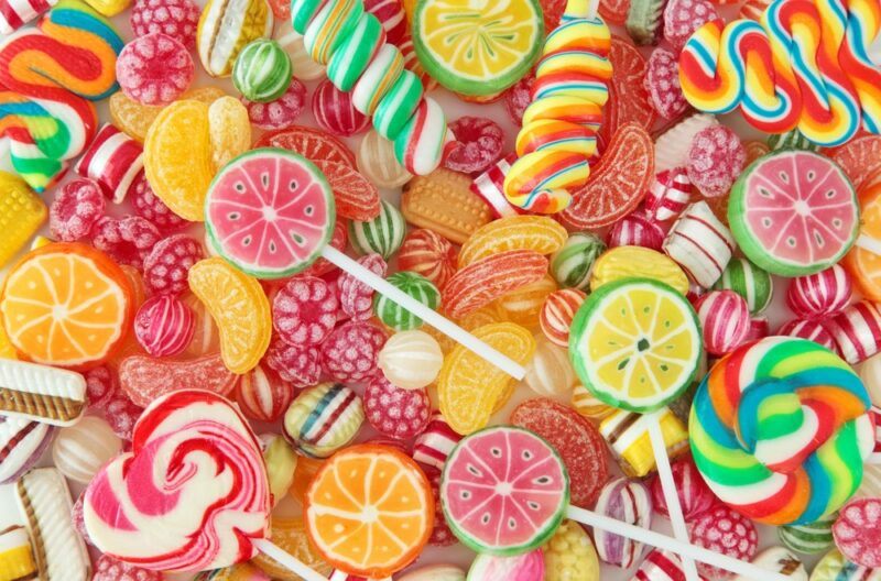 A large selection of unwrapped candy. Most pieces are brightly colored and many resemble fruit in some way.