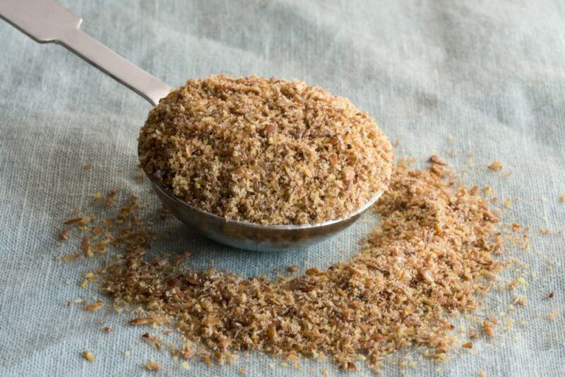 A large spoon with flaxseed powder on a table or a cloth