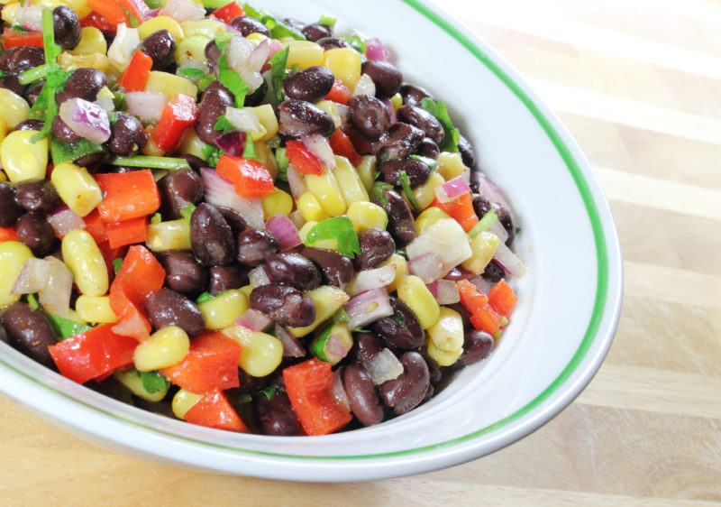 A light green dish filled with a bean salad