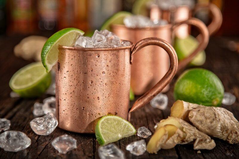 A line of Moscow mule cocktails, all in copper mugs with ice and lime