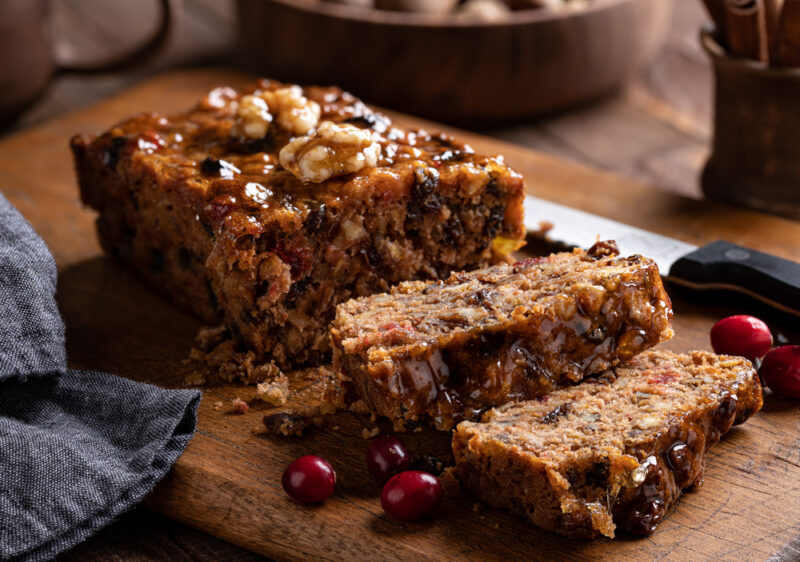 A loaf of fruitcake on a cutting board, highlighting the idea of the best brandy for fruitcake