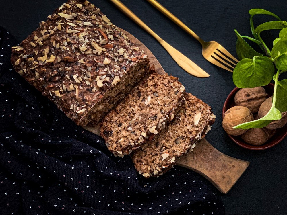 A wooden table with keto seed bread that has been cut into slices