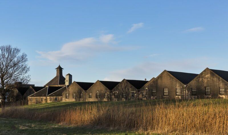 A long view of the BenRiach distillery, looking out over grass