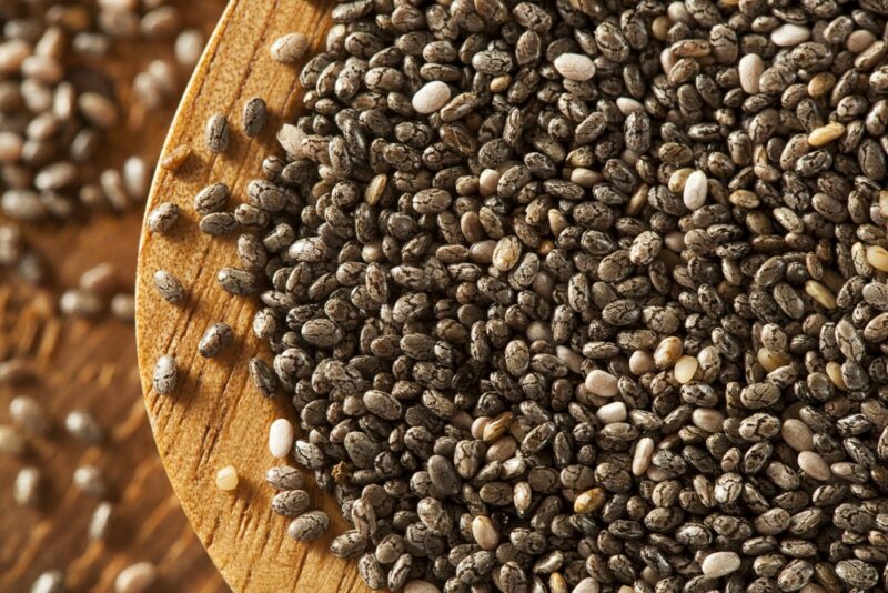 A macro image of chia seeds in a wooden bowl