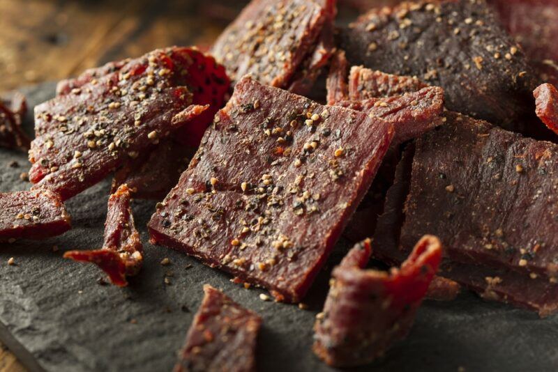 A close up image of jerky on a black table