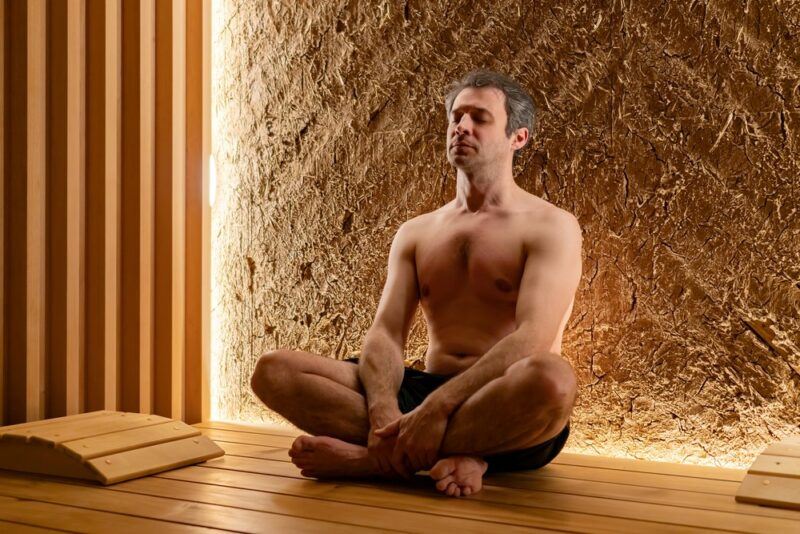 A man doing meditation or yoga in a sauna