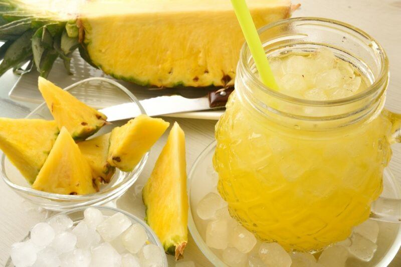 A glass containing a crushed pineapple juice cocktail called In The August Sun