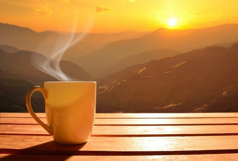 A steaming mug of tea outside in Vietnam highlighting the scenery