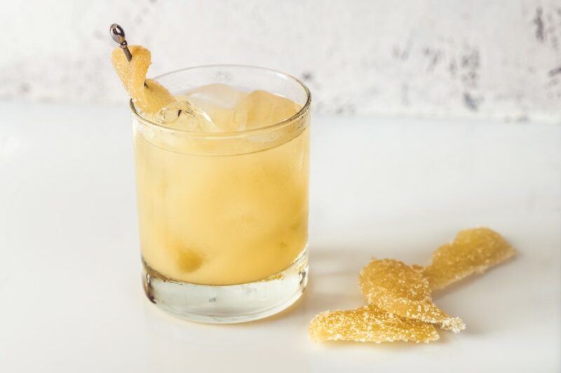 A white table with a penicillin cocktail and fruit as a garnish