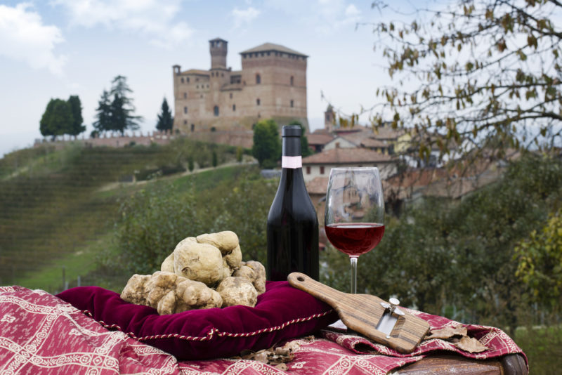 A picnic of truffles and red wine, with an old building in the background