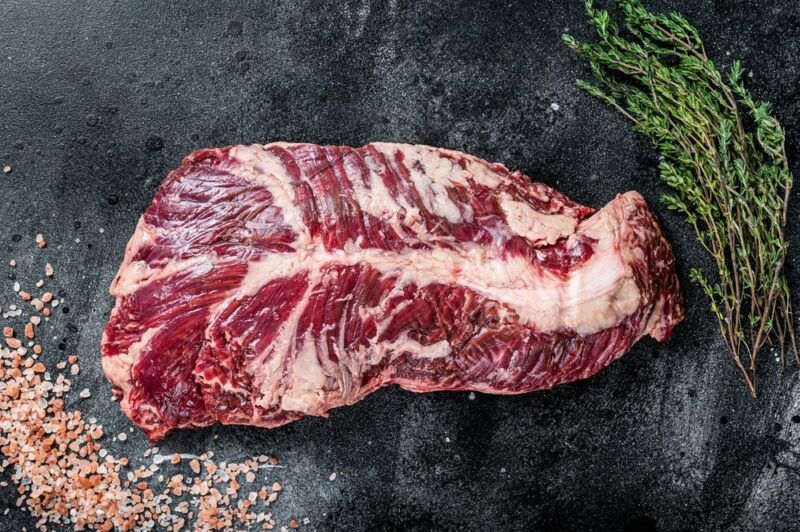 A black table with a piece of hanger steak