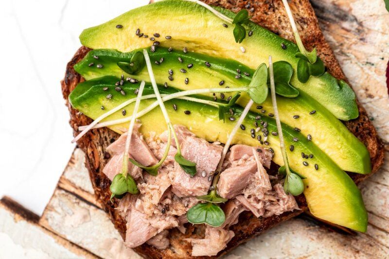 A piece of toast with avocados and tuna