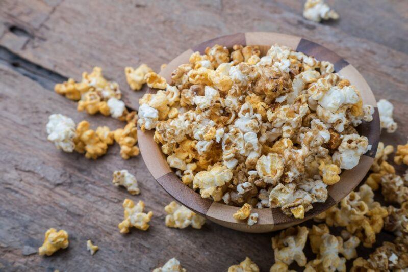 A wooden table with a pile of cheddar and smoked paprika popcorn