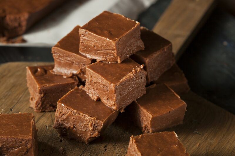 A pile of chocolate fudge squares on a wooden table