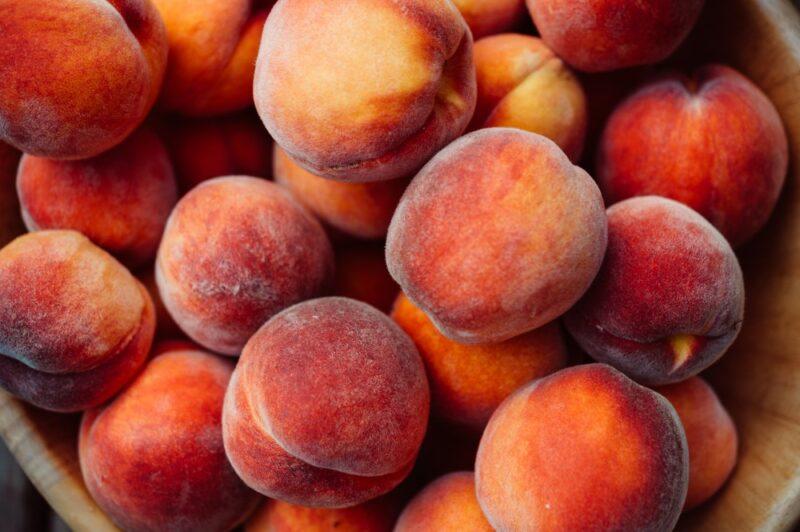 A pile of fresh fuzzy peaches