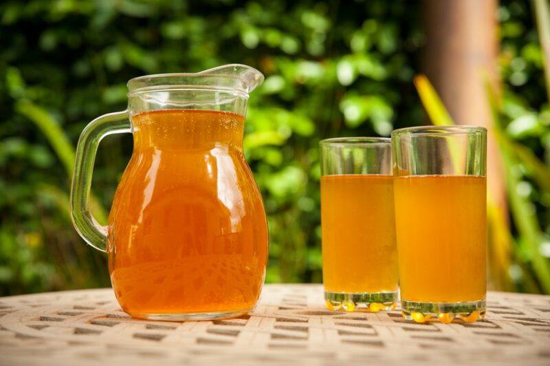 A table with a pitcher of iced tea next to two glasses of the tea