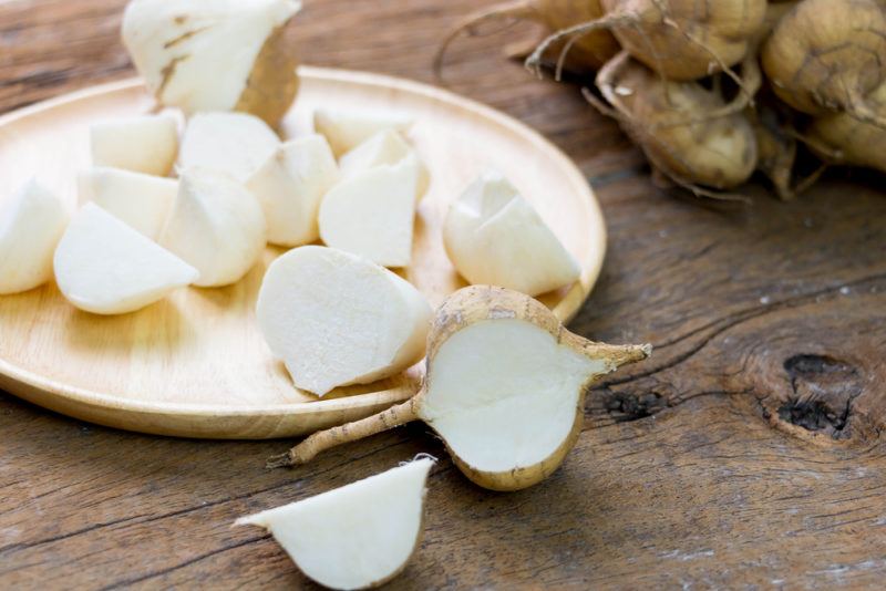 A plate of chopped jicama on a wooden table