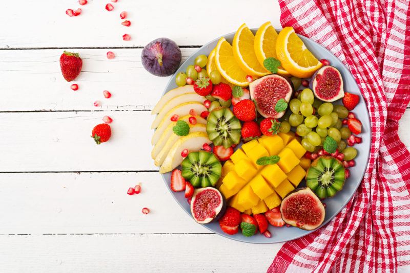 A plate of fresh tropical fruit on a wooden table