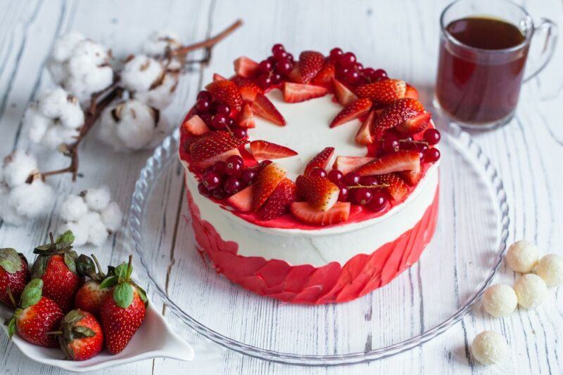 A glass tray with a champagne and strawberry cake