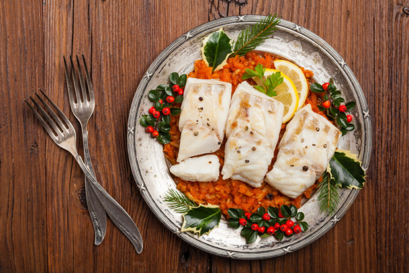 A plate with cooked fish | Food For Net A metal plate with cooked fish and veggies, next to two forks