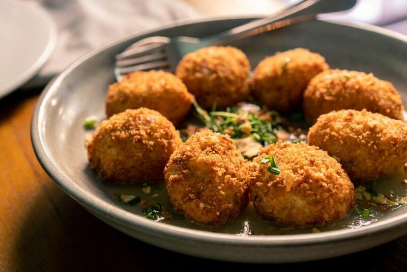 A small gray bowl filled with a circule of croquetas