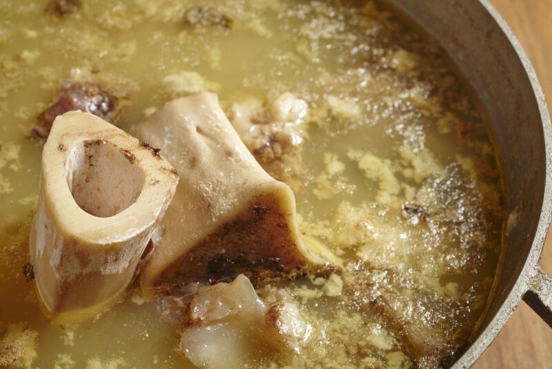 A large pot filled with bones simmering to make bone broth