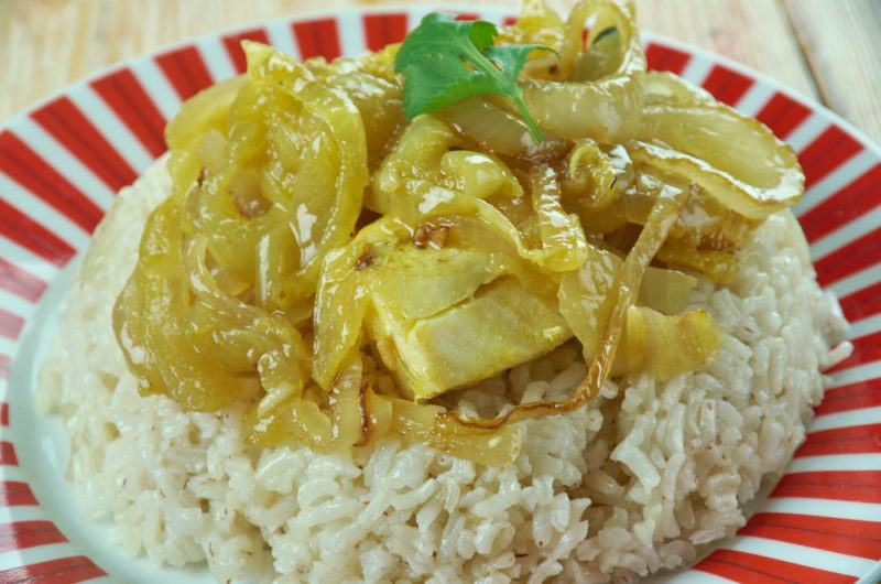 A red and white dish with rice and sayadiyah fish