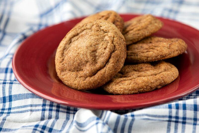 A red plate on a blue and white cloth with five root beer cookies