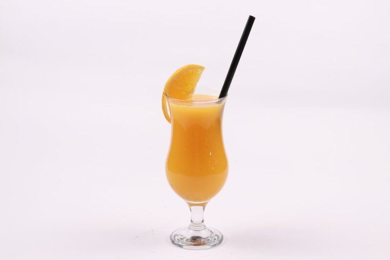 A single rum runner cocktail with a straw, isolated on white