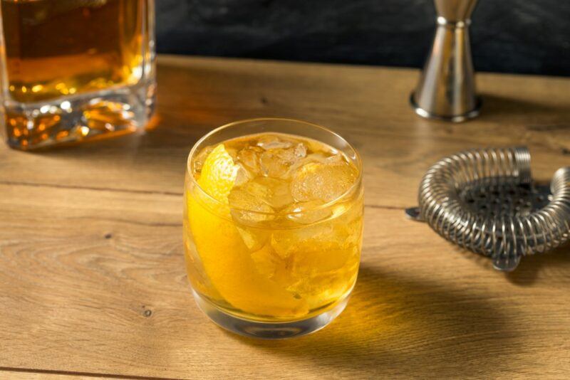 A wooden board containing a rusty nail cocktail