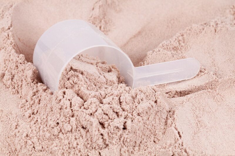 A plastic scoop embedded in protein powder