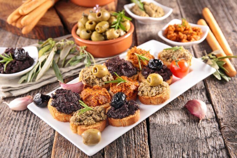 A platter of appetizers that have been made using olive tapenade