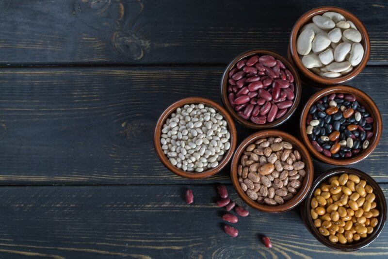 Six small bowls filled with beans