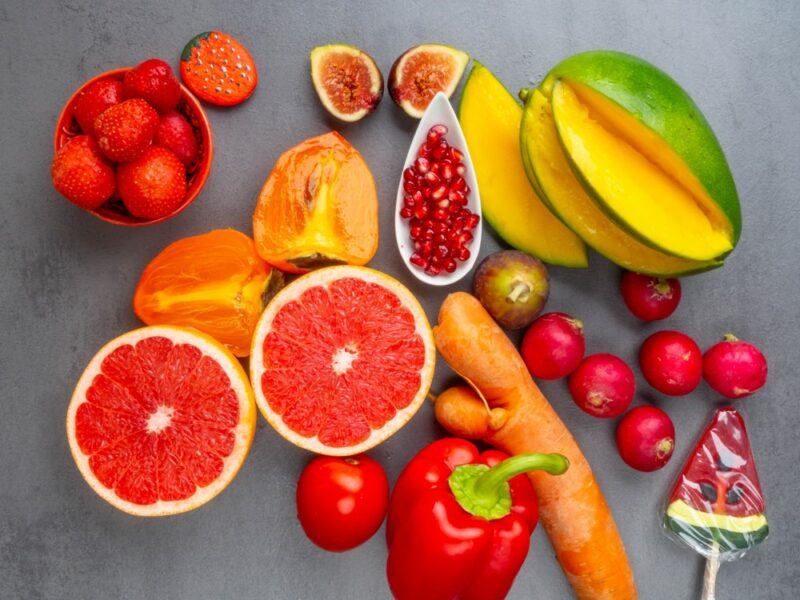 A gray table with brightly colored foods that contain carotenoids