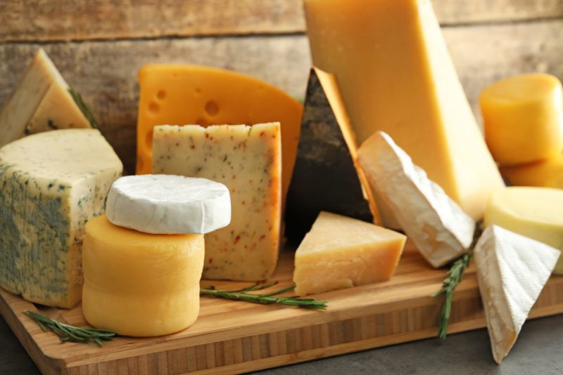 A selection of different hard cheeses on a wooden board