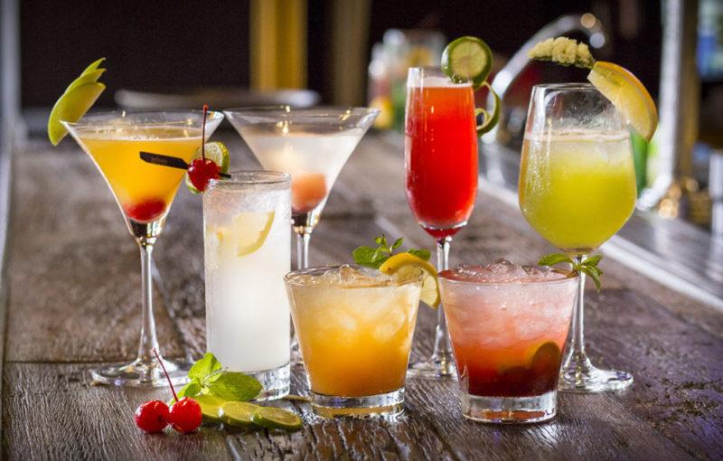 Various cocktails standing on a wooden table