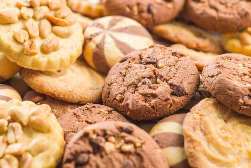 A pile of cookies of different colors and styles, including chocolate chip cookies