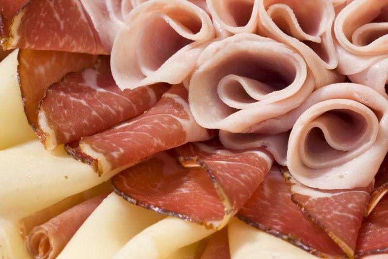 Various types of deli meat, some of which has been rolled