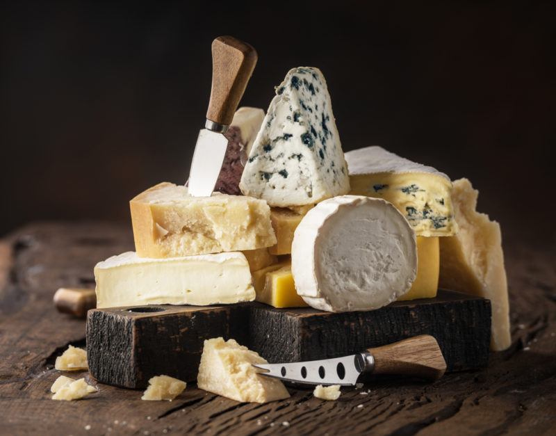 Many types of cheeses on a wooden table