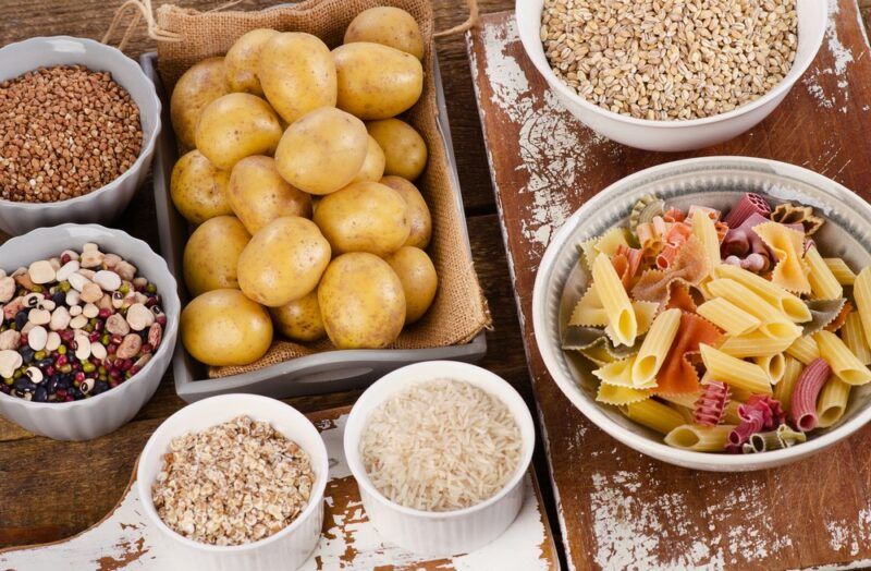 A selection of foods with carbs, including potatoes, pasta, and legumes